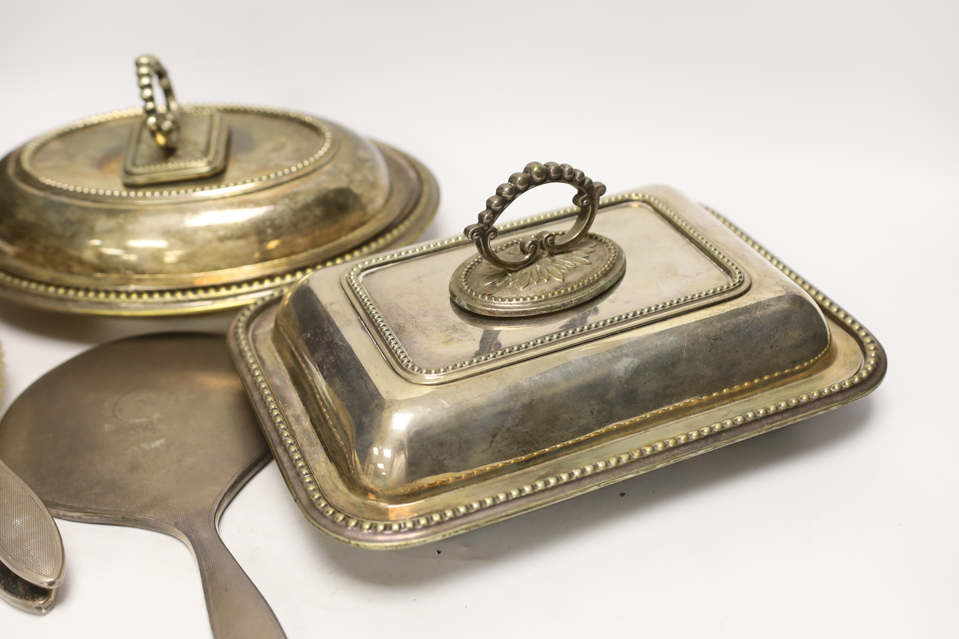 Three plated entrée dishes and a silver dressing table set
